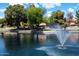 A tranquil view of a lake with a fountain, surrounded by lush trees and landscaping within the community at 401 N Cholla St, Chandler, AZ 85224