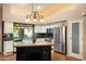 Bright kitchen with stainless steel appliances, granite counters, tile backsplash, kitchen island, and pendant lighting at 401 N Cholla St, Chandler, AZ 85224