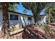 Mature backyard landscaping featuring a vintage metal bench, and brick patio area, surrounded by trees at 4142 N 35Th St, Phoenix, AZ 85018