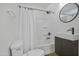 Bathroom features vanity, toilet and shower with black fixtures and round mirror at 432 W 1St St, Mesa, AZ 85201