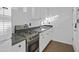Compact kitchen featuring white cabinets, granite countertops, stainless steel gas range, and modern faucet at 432 W 1St St, Mesa, AZ 85201