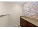 Functional bar area with granite countertop, cabinetry, and a brick accent wall at 4347 N 24Th Way, Phoenix, AZ 85016