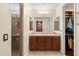 Bathroom featuring double sinks, cabinets, and a glass-enclosed shower with walk-in closet at 4347 N 24Th Way, Phoenix, AZ 85016