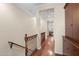 Hallway with hardwood floors, a wood railing, and a view into a sunlit bedroom at 4347 N 24Th Way, Phoenix, AZ 85016