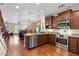 Open kitchen boasts granite countertops, stainless appliances, and wooden floors leading into the living room at 4347 N 24Th Way, Phoenix, AZ 85016