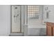 Bathroom features a shower, bathtub, and a window composed of glass blocks providing natural light at 4396 N School Hill Rd, Buckeye, AZ 85396