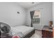 Simply designed bedroom with a black leather bed frame, light colored walls and gray tile flooring at 4396 N School Hill Rd, Buckeye, AZ 85396