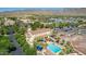 Aerial view of a community pool featuring palm trees, lounge chairs, and nearby residential area at 4396 N School Hill Rd, Buckeye, AZ 85396