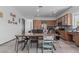 A large dining area with tile flooring seamlessly connects to an open-concept kitchen with wooden cabinets and stainless appliances at 4396 N School Hill Rd, Buckeye, AZ 85396