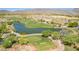 Scenic aerial view of the beautiful golf course with a water hazard, lush greenery, and desert landscape surrounding the green at 4396 N School Hill Rd, Buckeye, AZ 85396