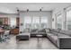 Bright living room with a large gray sectional sofa, tile floors, and ample natural light from large windows at 4396 N School Hill Rd, Buckeye, AZ 85396