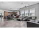 Spacious living room and open kitchen concept featuring tile floors, a large sectional, and modern lighting fixtures at 4396 N School Hill Rd, Buckeye, AZ 85396