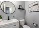 Contemporary half bathroom with round mirror, white sink, and modern fixtures at 4580 E Gagarinite Ln, San Tan Valley, AZ 85143