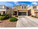 Inviting two-story home featuring a dark garage door, desert landscaping, and a covered front porch at 4580 E Gagarinite Ln, San Tan Valley, AZ 85143