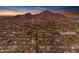 An aerial view of neighborhood homes and city with mountain backdrop on a sunny day with blue sky and street markers at 4596 E Calle Ventura --, Phoenix, AZ 85018