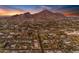 An aerial view of neighborhood homes and city with mountain backdrop on a sunny day with blue sky at 4596 E Calle Ventura --, Phoenix, AZ 85018
