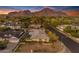 An aerial view of a beautiful home, landscaped yard and pool under a colorful sunset sky with mountain backdrop at 4596 E Calle Ventura --, Phoenix, AZ 85018