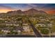 An aerial view of neighborhood homes and city with mountain backdrop on a sunny day with blue sky at 4596 E Calle Ventura --, Phoenix, AZ 85018