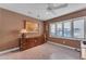 Bedroom with brown walls, carpet, a ceiling fan, and a vintage wooden cabinet at 4596 E Calle Ventura --, Phoenix, AZ 85018
