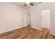 Bedroom featuring wood flooring, a ceiling fan, and an open door with access to closet and hallway at 4746 W Taro Dr, Glendale, AZ 85308