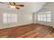 Bright bedroom with wood floors, large windows, and modern ceiling fan at 4746 W Taro Dr, Glendale, AZ 85308