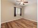 Bedroom with wood flooring, ceiling fan, a window with curtains, and a light neutral color scheme at 4746 W Taro Dr, Glendale, AZ 85308