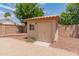 Backyard storage shed features a double door entry, tile roof, and adjacent low-maintenance landscaping at 4746 W Taro Dr, Glendale, AZ 85308