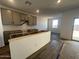 New kitchen with gray cabinets and a center island, with sliding door access to the backyard at 47692 W Moeller Rd, Maricopa, AZ 85139