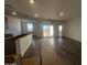 Bright, open living room featuring wood-style flooring and natural light from a sliding glass door at 47692 W Moeller Rd, Maricopa, AZ 85139