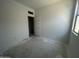 A freshly painted bedroom with a neutral color palette, awaiting flooring installation, and a window for natural light at 47719 W Moeller Rd, Maricopa, AZ 85139