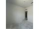 An airy bedroom awaiting flooring, featuring freshly painted walls, an open doorway, and ample natural light at 47719 W Moeller Rd, Maricopa, AZ 85139