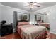 Cozy bedroom featuring terra-cotta floors, window, ceiling fan, and closet with mirrored doors at 4804 S Elm St, Tempe, AZ 85282