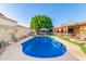 Backyard pool and entertainment area with water feature, covered patio, and lush artificial turf at 4804 S Elm St, Tempe, AZ 85282