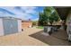 Spacious backyard featuring gravel, a storage shed, artificial grass, and mature trees, offering outdoor living at 650 N 65Th Way, Mesa, AZ 85205