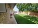Expansive backyard boasts artificial turf, mature trees, and a storage shed, creating a serene outdoor space at 650 N 65Th Way, Mesa, AZ 85205