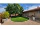 Lush backyard with artificial turf, mature trees, gravel accents, and a covered patio, perfect for entertaining at 650 N 65Th Way, Mesa, AZ 85205