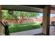 Covered patio view showcases a spacious backyard with artificial turf and mature trees, perfect for relaxing at 650 N 65Th Way, Mesa, AZ 85205