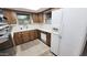 Cozy kitchen featuring wooden cabinets, white appliances, and a garden window at 650 N 65Th Way, Mesa, AZ 85205