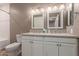 Neutral bathroom with double sink vanity, white cabinets, wall mounted lighting, and framed mirrors at 750 E Northern E Ave # 2145, Phoenix, AZ 85020