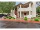 Multi-level condo building featuring well maintained landscaping and white stucco facade with red accents and covered entryways at 750 E Northern E Ave # 2145, Phoenix, AZ 85020