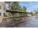 Community parking with covered parking and grass areas with mature trees at 750 E Northern E Ave # 2145, Phoenix, AZ 85020