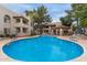 Community pool surrounded by lounge furniture, landscaping, and several apartment buildings at 750 E Northern E Ave # 2145, Phoenix, AZ 85020