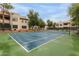Spacious tennis court with green and blue surfaces, surrounded by condo buildings and mature trees on a clear day at 750 E Northern E Ave # 2145, Phoenix, AZ 85020