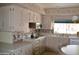 Bright kitchen with white cabinetry, modern appliances, and stylish backsplash at 8310 E Deep Canyon Ct, Mesa, AZ 85208