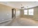 Spacious carpeted bedroom with a ceiling fan, three windows, and access to an arched doorway at 9302 E Horseshoe Bend Dr, Scottsdale, AZ 85255