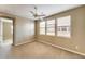 Bedroom with carpeted floor, three windows, ceiling fan, and an open doorway to another room at 9302 E Horseshoe Bend Dr, Scottsdale, AZ 85255