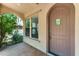 Covered entryway featuring a brown door with window insert and desert landscaping at 9302 E Horseshoe Bend Dr, Scottsdale, AZ 85255