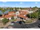 Stunning aerial view of a lakeside villa with an American flag, swaying palm trees, and elegant red tile roof at 1001 N Peppertree Dr, Gilbert, AZ 85234