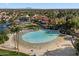 Aerial view of a community lagoon featuring a sandy beach and lush palm trees at 1001 N Peppertree Dr, Gilbert, AZ 85234