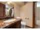 Bathroom featuring granite countertops, a mirror, and a toilet, providing a functional and stylish space at 1001 N Peppertree Dr, Gilbert, AZ 85234